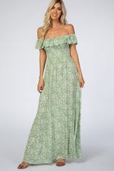 woman wearing a green floral off the shoulder smocked maternity maxi dress