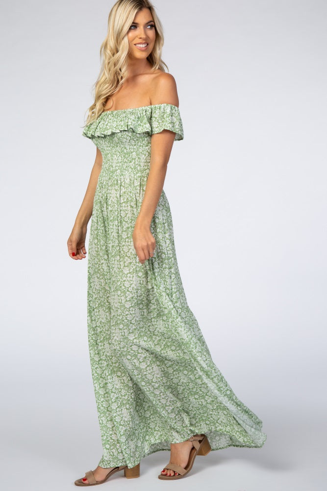 woman wearing a green floral off-the-shoulder maxi dress with ruffle details and a flowy silhouette