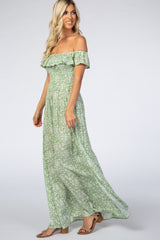woman wearing a green floral off-the-shoulder maxi dress with ruffle details and a flowy silhouette