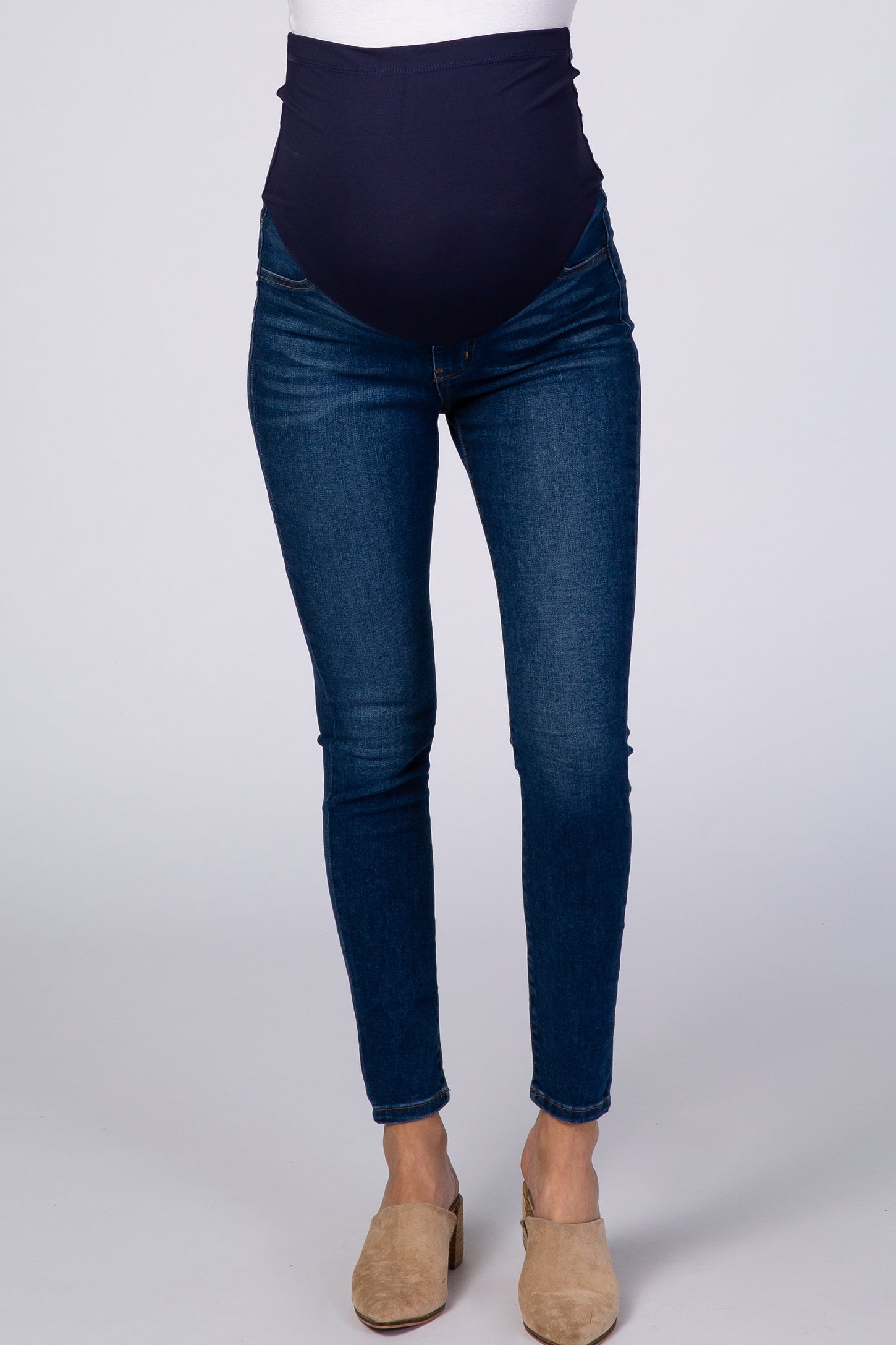 woman wearing dark blue maternity skinny jeans with a high elastic waistband and a fitted style
