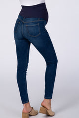 woman wearing dark blue maternity skinny jeans with a supportive waistband, showing a visible baby bump