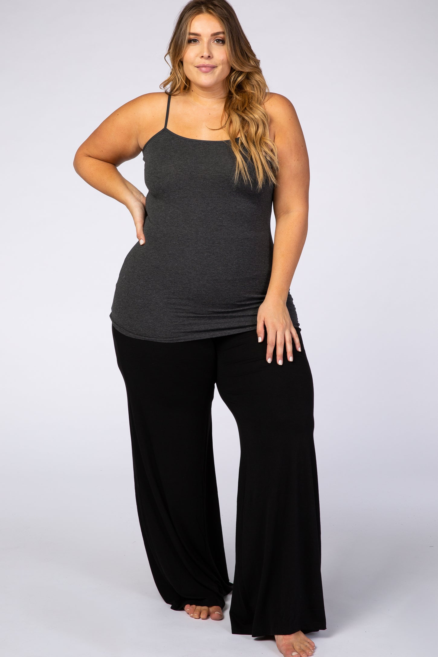 woman wearing a gray spaghetti strap tank top and black wide-leg pants