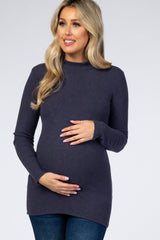 woman wearing a dark gray ribbed maternity top and holding her baby bump