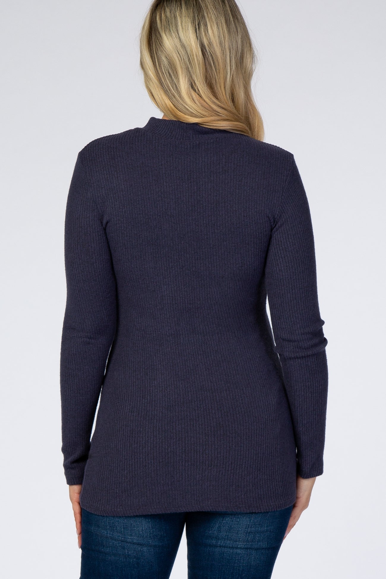 woman wearing a dark purple ribbed maternity top, showing the back view with long sleeves and a fitted style