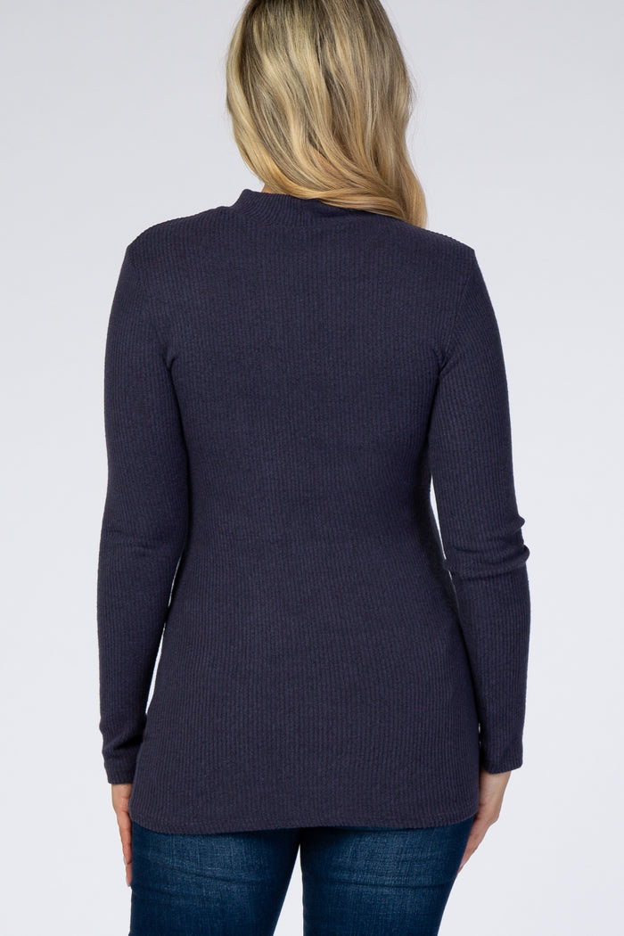 woman wearing a dark purple ribbed maternity top, showing the back view with long sleeves and a fitted style