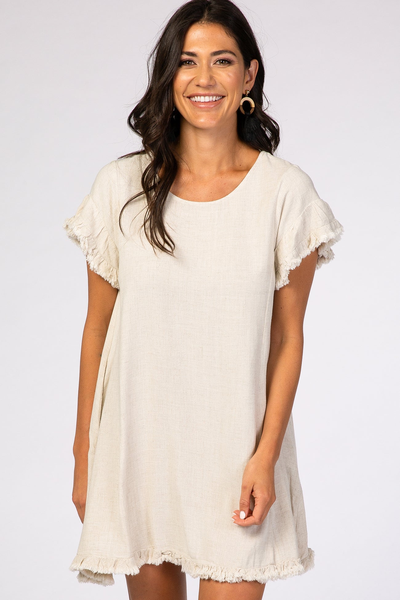 woman wearing a beige short sleeve linen dress with frayed edges and a relaxed fit