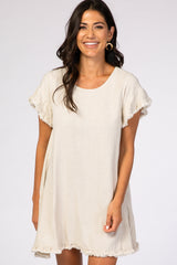 woman wearing a beige short sleeve linen dress with frayed edges and a relaxed fit