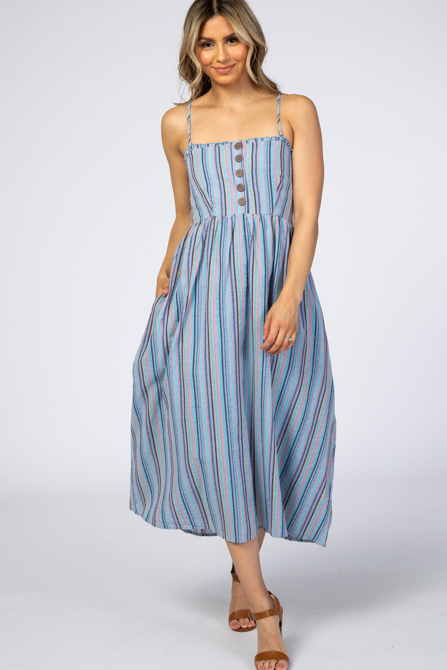 woman wearing a blue striped sleeveless maxi dress with buttons down the front and a relaxed fit
