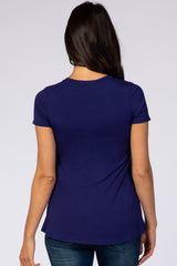 woman wearing a navy blue short sleeve top, view from the back