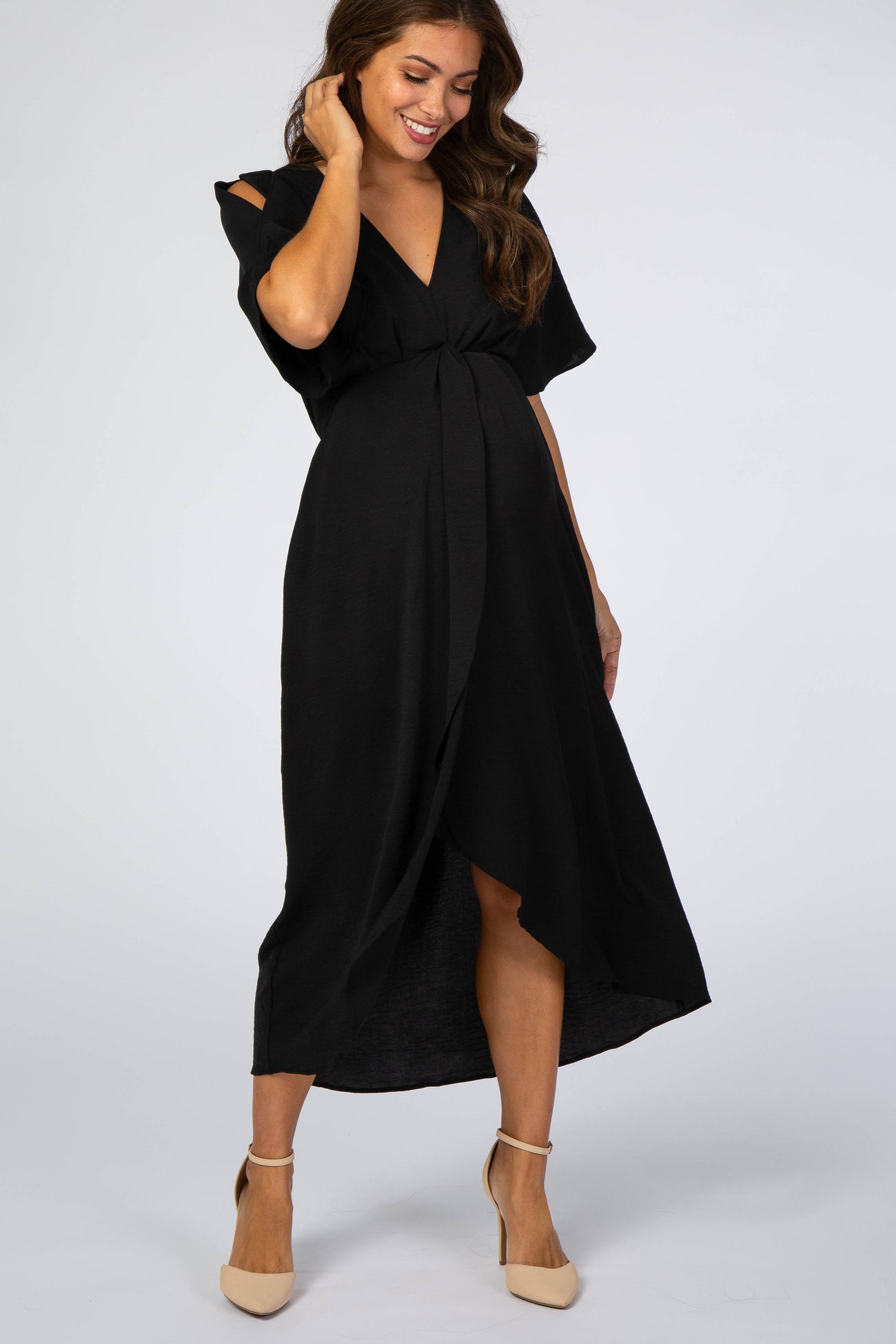 woman wearing a black maternity wrap dress with short sleeves and a knotted detail, showing her baby bump