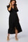 woman wearing a black maternity wrap dress with short sleeves and a knotted detail, showing her baby bump