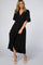 woman wearing a black wrap dress with short flutter sleeves and a deep v-neckline, standing in a model pose