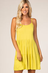 woman wearing a bright yellow spaghetti strap tiered dress with a relaxed fit