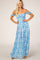 blonde woman wearing a blue and white floral off-the-shoulder smocked maxi dress