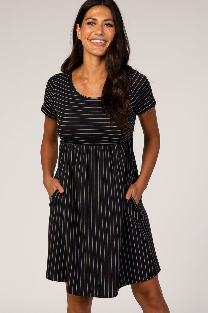 woman wearing a black and white striped short sleeve dress with pockets and a fitted bodice