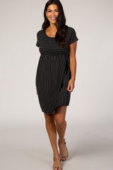 woman wearing a black and white striped short sleeve maternity dress with tan sandals