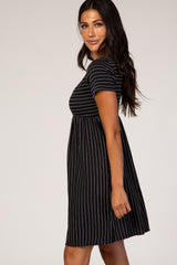 woman wearing a black striped short sleeve dress with a flared skirt