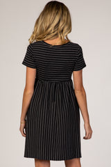 woman wearing a black and white striped maternity dress with short sleeves and a fitted waistline