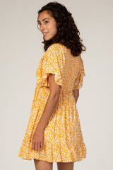 woman wearing a yellow floral short sleeve dress with a flared skirt and ruffled sleeves
