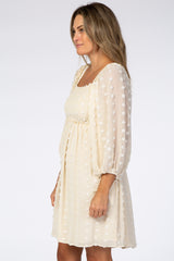 woman wearing a cream-colored short dress with puff sleeves and textured polka dots