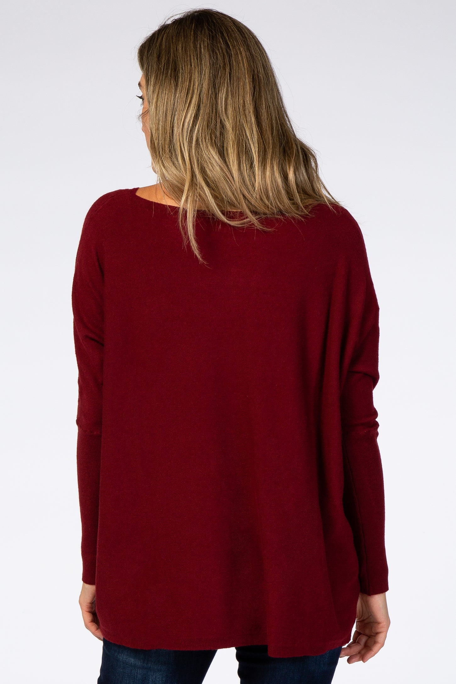 woman wearing a burgundy oversized sweater viewed from the back, styled with a relaxed fit and long sleeves