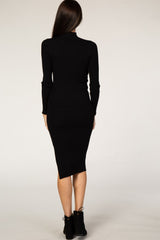 Back view of a woman wearing a long sleeve black ribbed midi dress and black ankle boots