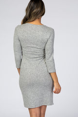 woman wearing a gray three-quarter sleeve fitted dress, showing the back view