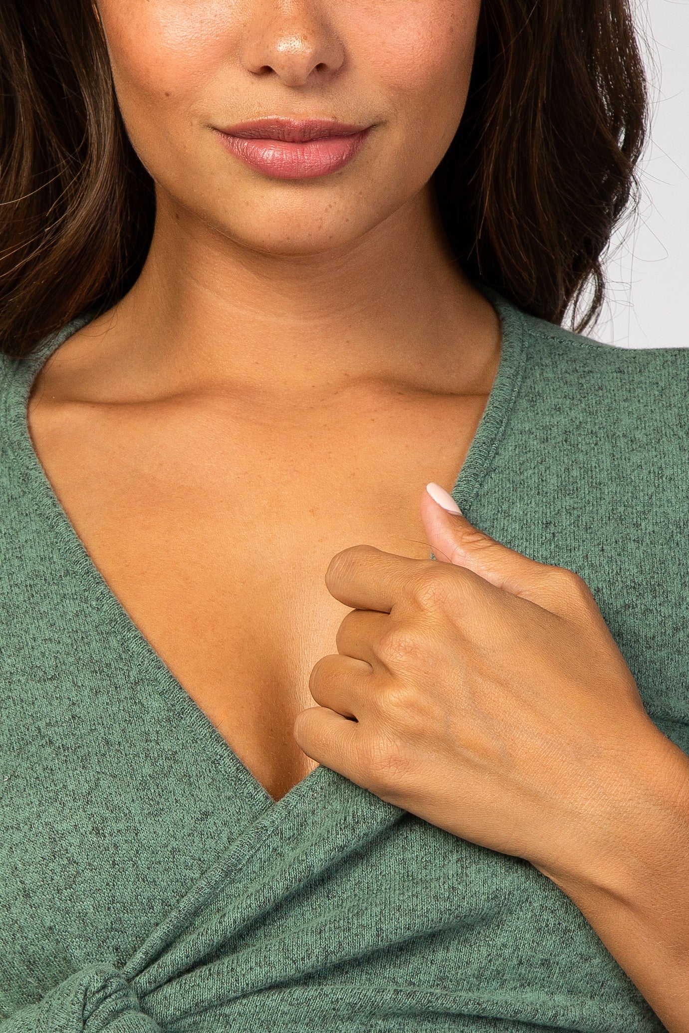 woman wearing a green v-neck maternity top with a tied knot detail at the waist