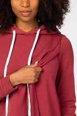 woman wearing a maroon long sleeve hooded top with drawstrings and a stylish front knot detail