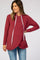 woman wearing a burgundy maternity hoodie with a crossover design and white drawstrings, styled with jeans
