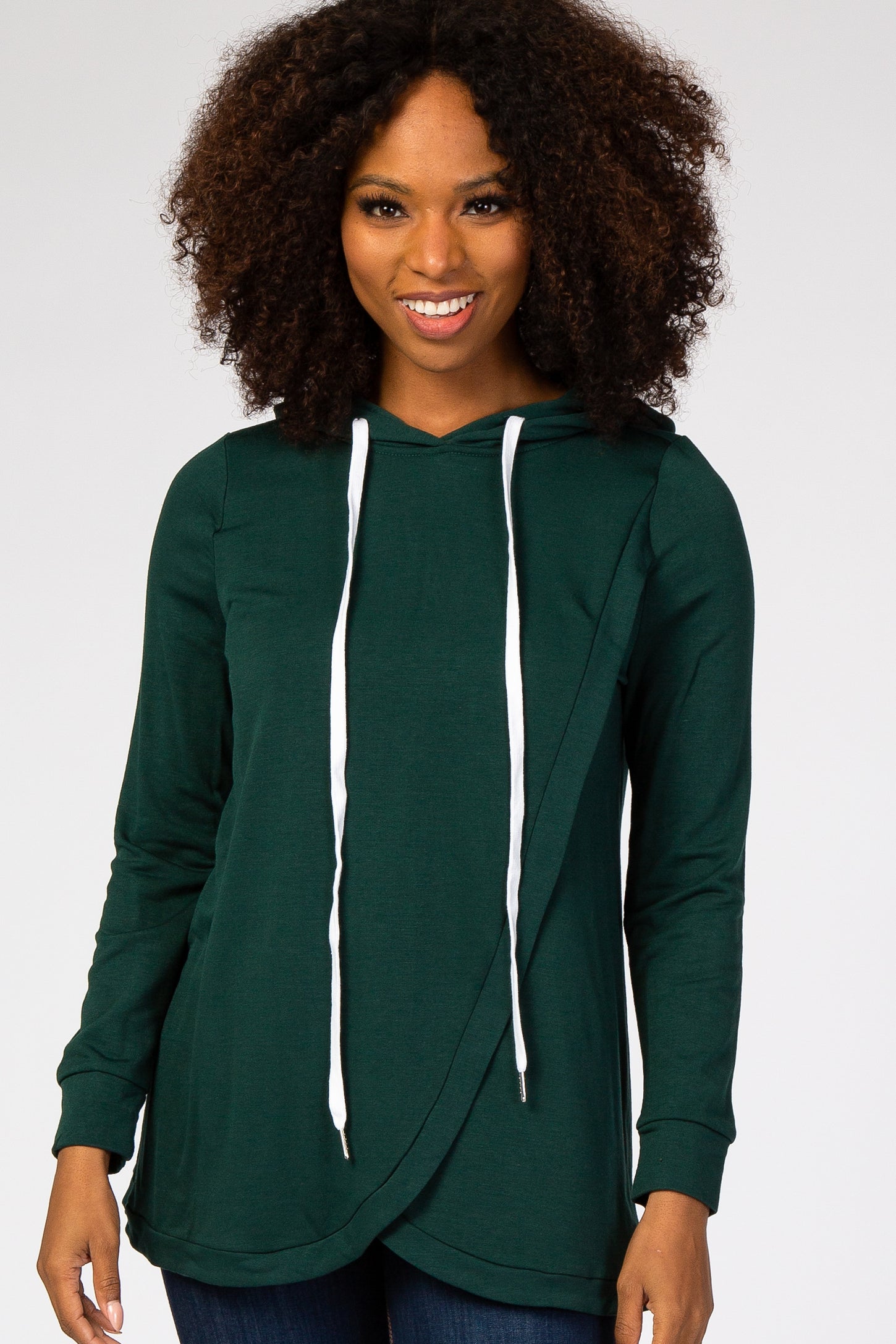 woman wearing a dark green long sleeve hoodie with a crossover front and white drawstrings
