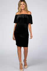 woman wearing a black velvet off the shoulder maternity dress with ruffle detail and beige heels