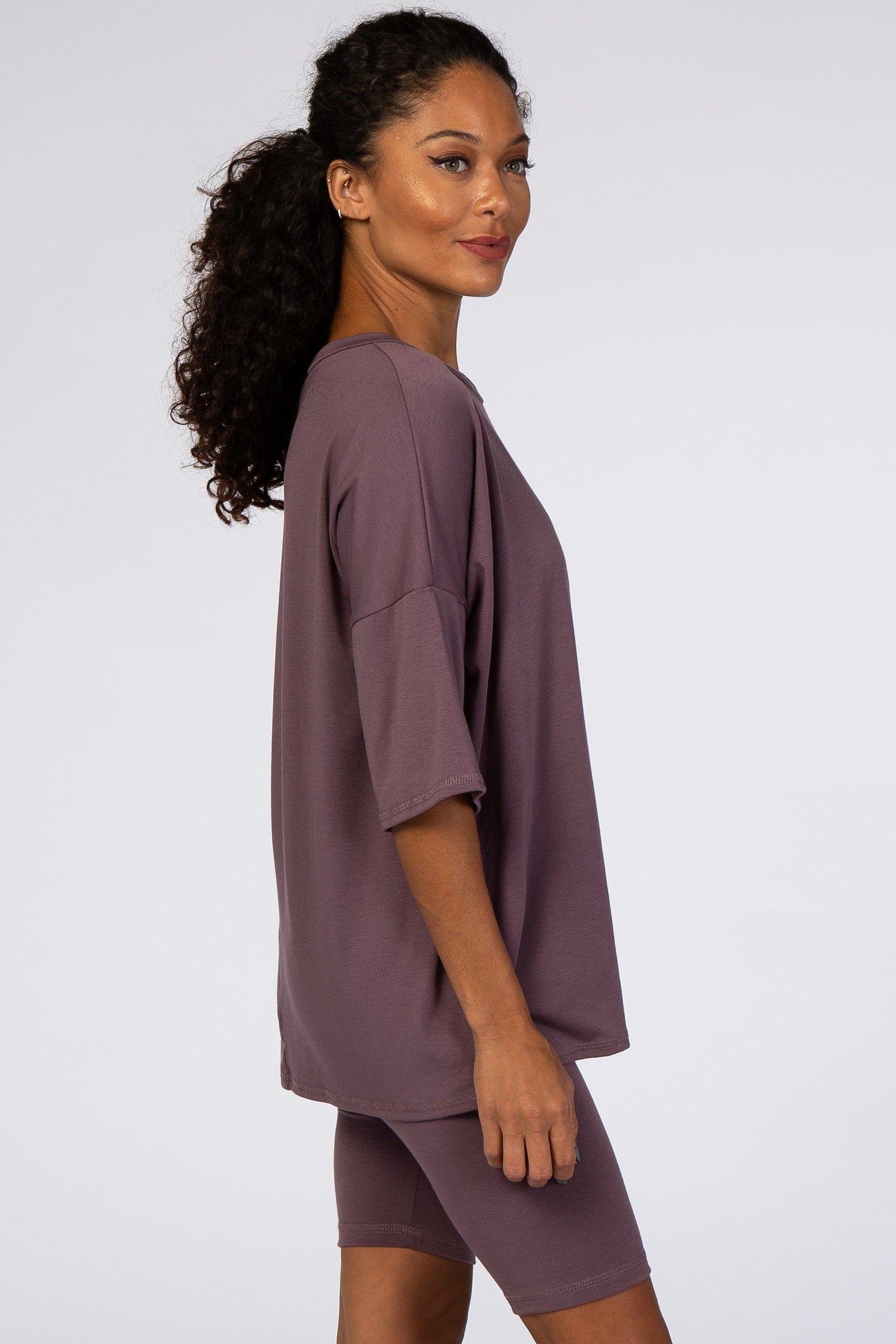 woman wearing a loose-fitting mauve oversized t-shirt and matching bike shorts