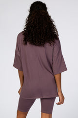 woman wearing a loose-fitting mauve oversized t-shirt and matching bike shorts, viewed from the back