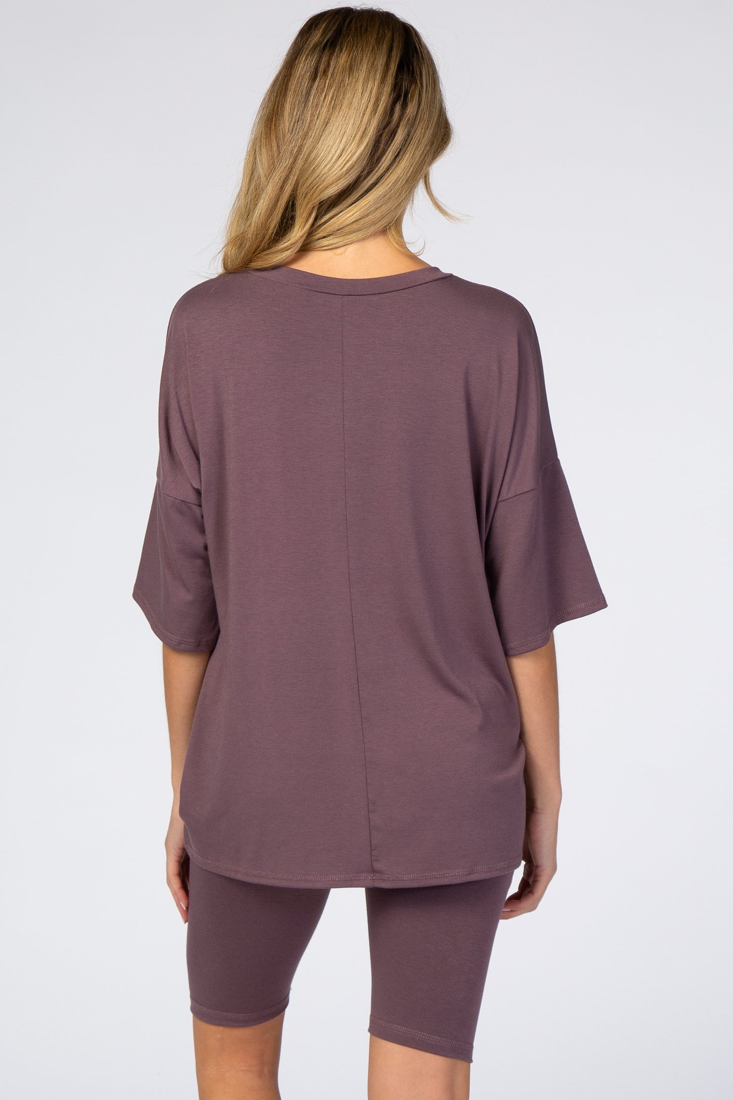 woman wearing a relaxed fit mauve maternity top with short sleeves and matching bike shorts from the back