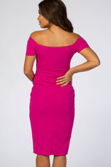 woman wearing a bright pink off-shoulder maternity dress, showing a fitted silhouette from the back