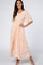 woman wearing a blush pink floral maxi dress with short sleeves and a fitted bodice, posing elegantly