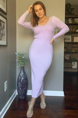 woman wearing a light purple ribbed long sleeve midi dress with a scoop neckline and a side slit