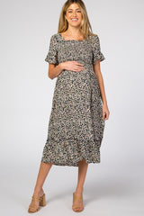 woman wearing a black floral maternity midi dress with ruffle sleeves and a visible baby bump