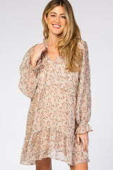 smiling woman wearing a long sleeve floral print maternity dress with ruffle details