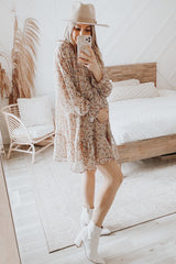 woman wearing a floral maternity dress and showing her baby bump while posing in a stylish room