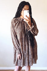woman wearing a leopard print long sleeve dress with a ruffled hem and high neck detail