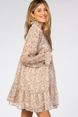 woman wearing a floral maternity dress with ruffled collar and bell sleeves, showing her baby bump