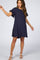 woman wearing a navy blue linen shift dress with frayed ruffle sleeves and hemline