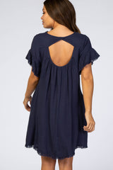 back view of woman wearing navy blue maternity dress with cutout back and fringe hem
