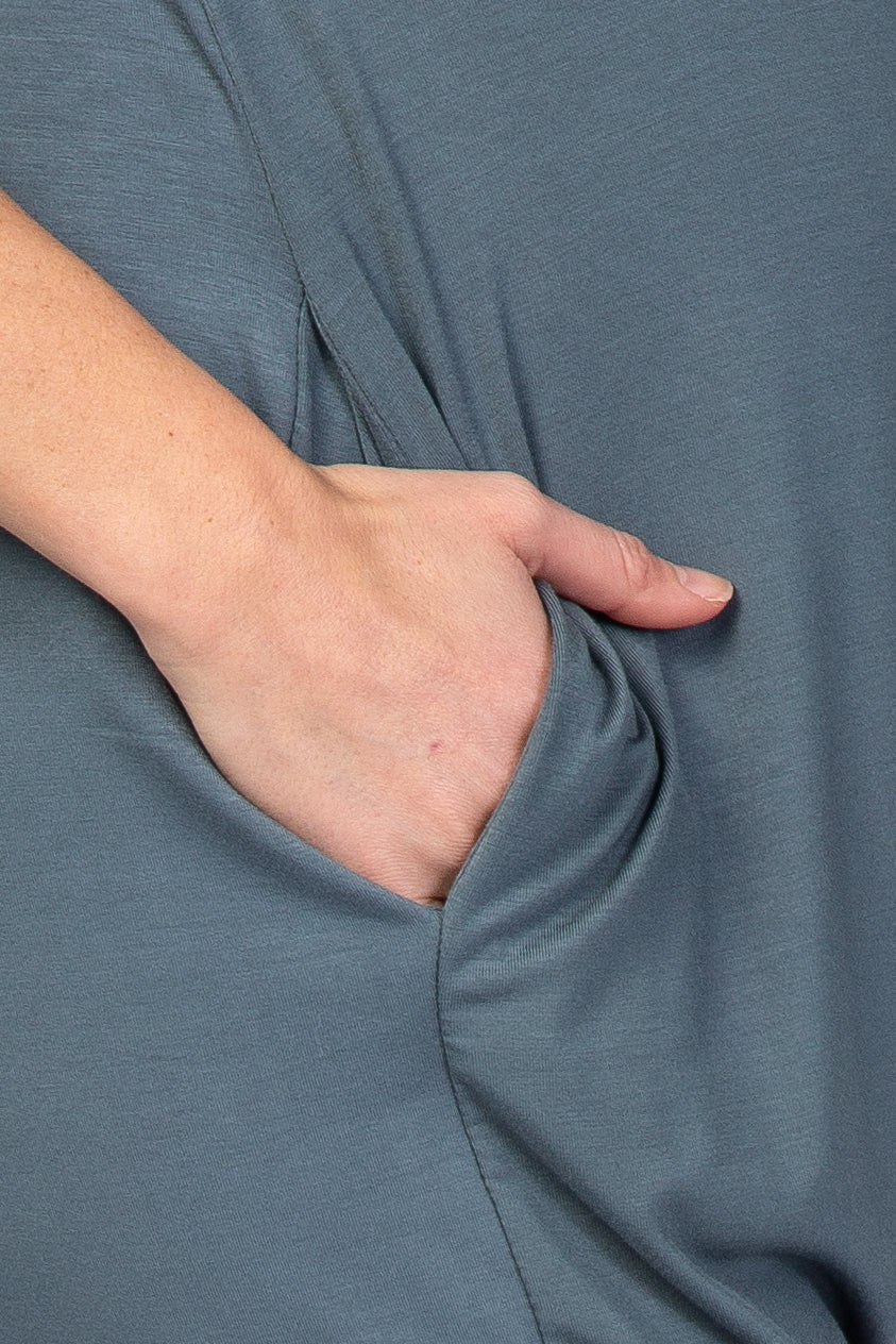 woman wearing a teal maternity dress with a side pocket detail