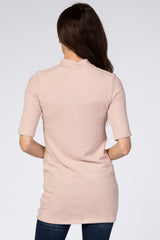 woman wearing a light pink short sleeve tunic sweater, view from the back