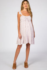 woman wearing a white and purple floral maternity mini dress with ruffle straps and brown mule heels