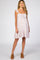 woman wearing a white and purple floral maternity mini dress with ruffle straps and brown mule heels