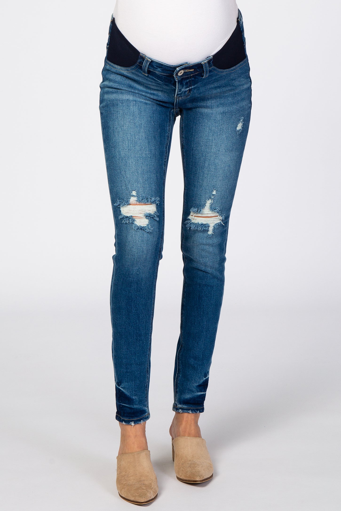 woman wearing maternity distressed skinny jeans in blue denim with a dark waistband and no baby bump visible